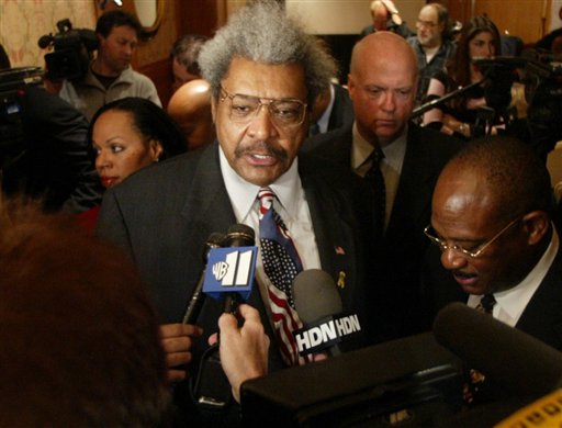 Boxing promoter Don King, center, and his attorney Willie Gary, right, are surrounded by reporters after a news conference in 2005 in New York. King filed a $2.5 billion defamation suit in Broward County, Fla. claiming he was portrayed in a false light on an ESPN "SportsCentury" segment aired last May. King lost the case due to a lack of "actual malice" on ESPN's part. (AP Photo/Mary Altaffer, used with permission from the Associated Press)