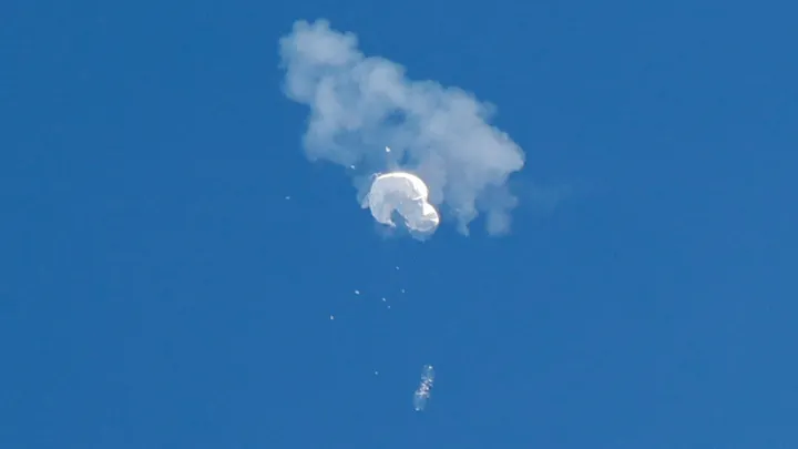 The suspected Chinese spy balloon drifts to the ocean after being shot down off the coast in Surfside Beach, S.C., on Saturday. (REUTERS/Randall Hill)