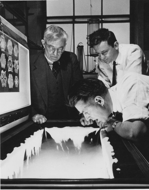 On the left, physicist Bernard Vonnegut, Brother of Vincent Schaefer. Vincent Schaefer on the right, and Nobel winner Irving Langmuir standing with glasses next to Bernard Vonnegut. They are seeding a snow cloud in Schaefer’s icebox. | credit: Museum of Innovation and Science Schenectady